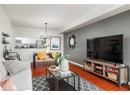 Living room featuring baseboards, wood finished floors, and an inviting chandelier
