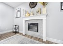 Living room featuring wood finished floors, a tiled fireplace, and baseboards