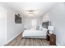 Bedroom with a chandelier, a textured ceiling, wood finished floors, and baseboards
