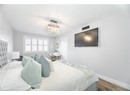 Bedroom with a chandelier, a textured ceiling, wood finished floors, and baseboards
