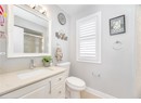 Full bath featuring a shower stall, vanity, baseboards, and toilet