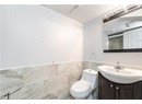 Bathroom featuring vanity, toilet, a wainscoted wall, visible vents, and tile walls