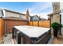 Wooden terrace featuring a jacuzzi and fence