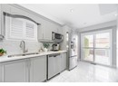 Kitchen featuring appliances with stainless steel finishes, gray cabinets, decorative backsplash, marble finish floor, and a sink