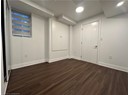 Basement featuring dark wood-type flooring, baseboards, and recessed lighting