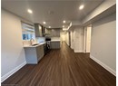 Kitchen with light countertops, a sink, gray cabinets, baseboards, and range