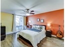 Bedroom featuring wood-type flooring, baseboards, and ceiling fan