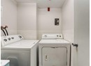 Washroom featuring separate washer and dryer, tile walls, and wainscoting