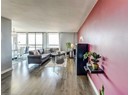 Living area featuring wood finished floors, a chandelier, and expansive windows