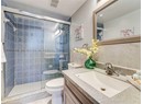 Bathroom featuring toilet, a shower stall, and vanity