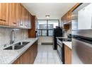 Kitchen featuring appliances with stainless steel finishes, a sink, tasteful backsplash, light tile patterned floors, and a baseboard heating unit