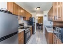 Kitchen featuring appliances with stainless steel finishes, a sink, brown cabinetry, a chandelier, and a textured ceiling