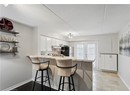 Kitchen with freestanding refrigerator, under cabinet range hood, decorative backsplash, light countertops, and a textured ceiling