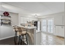 Kitchen with under cabinet range hood, appliances with stainless steel finishes, decorative backsplash, a peninsula, and a kitchen bar