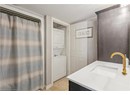 Bathroom with stacked washer / dryer, vanity, and a shower with shower curtain