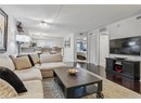 Living room with wood finished floors, a textured ceiling, and baseboards