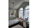 Bedroom featuring lofted ceiling, wood finished floors, and a chandelier