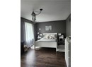Bedroom with wood finished floors, a textured ceiling, and a chandelier