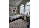 Bedroom featuring lofted ceiling, a chandelier, wood finished floors, and a textured ceiling