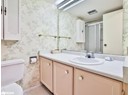 Bathroom featuring toilet, vanity, wallpapered walls, a shower stall, and tile patterned flooring