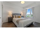 Bedroom with a tray ceiling, baseboards, and dark wood finished floors