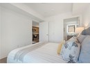 Bedroom with dark wood-style flooring, baseboards, and a closet