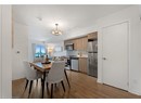Dining area with a chandelier, rail lighting, wood finished floors, and baseboards