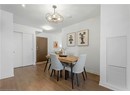 Dining room with wood finished floors, a chandelier, and baseboards