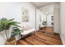 Living area featuring stacked washer / dryer, wood finished floors, and baseboards
