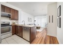 Kitchen featuring stainless steel appliances, a sink, dark brown cabinets, and a peninsula