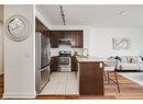 Kitchen with stainless steel appliances, a sink, open floor plan, a breakfast bar, and dark brown cabinetry