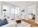 Living area with healthy amount of natural light, wood finished floors, a wall of windows, and baseboards