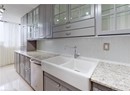 Kitchen featuring a sink, gray cabinetry, dishwasher, decorative backsplash, and light tile patterned floors