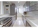 Kitchen with appliances with stainless steel finishes, a sink, gray cabinetry, and tasteful backsplash
