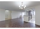 Kitchen with appliances with stainless steel finishes, a chandelier, wood finished floors, decorative light fixtures, and baseboards