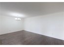 Spare room with a chandelier, dark wood-style floors, ornamental molding, and baseboards