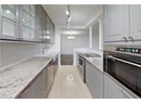 Kitchen featuring stainless steel appliances, a chandelier, a sink, light stone countertops, and light tile patterned floors