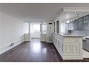 Kitchen with gray cabinetry, ornamental molding, glass insert cabinets, dark wood finished floors, and a sink
