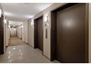 Hall with elevator, light tile patterned floors, and baseboards