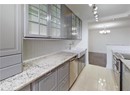 Kitchen featuring appliances with stainless steel finishes, baseboards, a chandelier, gray cabinetry, and tasteful backsplash