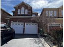 View of front of home featuring a garage, asphalt driveway, and brick siding