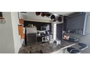 Kitchen with appliances with stainless steel finishes, a peninsula, dark countertops, and dark cabinetry