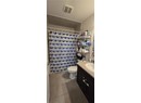Bathroom with vanity, tile patterned flooring, a shower with shower curtain, and toilet