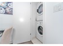 Laundry room featuring stacked washer and dryer, laundry area, and light tile patterned floors