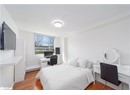 Bedroom featuring light wood-type flooring, a desk, and baseboards
