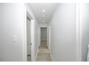 Hall with baseboards, light wood-style floors, and recessed lighting