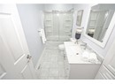Bathroom featuring vanity, shower / bath combination with glass door, toilet, baseboards, and marble finish floor