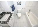 Full bathroom featuring toilet, vanity, a bath, walk in shower, and baseboards