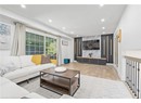 Living room with recessed lighting, wood finished floors, baseboards, and an accent wall