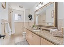 Full bath with tile patterned flooring, toilet, vanity, tile walls, and curtained shower